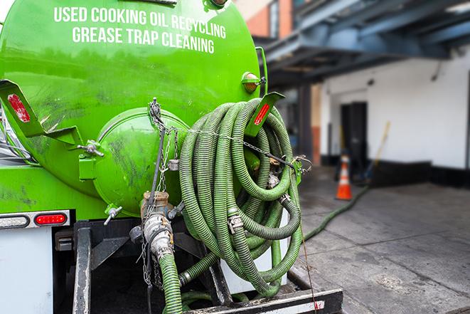 a grease trap being pumped by a sanitation technician in East Berlin, CT